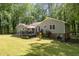 Spacious backyard with a deck, patio furniture, mature trees, and lush landscaping, perfect for outdoor entertaining at 7200 Rabbit Run, Wake Forest, NC 27587