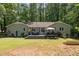 Lush backyard featuring a spacious deck and patio furniture surrounded by mature trees and landscaping at 7200 Rabbit Run, Wake Forest, NC 27587