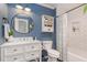 Stylish bathroom with blue walls, white subway tile, modern vanity, and a round mirror at 7200 Rabbit Run, Wake Forest, NC 27587