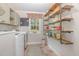 Functional laundry room featuring modern appliances, open shelving, and a bright window at 7200 Rabbit Run, Wake Forest, NC 27587