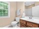 Bathroom with a single sink vanity, toilet, and a sunlit window providing ample natural light at 72103 Moseley, Chapel Hill, NC 27517