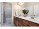 Bathroom featuring a double vanity, wooden cabinets, and a separate bathtub with tile surround at 72103 Moseley, Chapel Hill, NC 27517