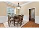 Bright dining room features hardwood floors, a modern chandelier, and a large window with natural light at 72103 Moseley, Chapel Hill, NC 27517