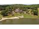 Aerial view displaying the clubhouse, golf course and a pond within a serene golf community at 72103 Moseley, Chapel Hill, NC 27517