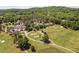 This aerial view shows a golf course and pond with a country club offering lush landscaping and serene views at 72103 Moseley, Chapel Hill, NC 27517
