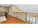 Hallway overlooking great room features wood floors, railings, and natural light at 72103 Moseley, Chapel Hill, NC 27517