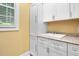 Bright laundry room featuring a sink and ample storage in white cabinets for convenience at 72103 Moseley, Chapel Hill, NC 27517