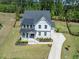 Aerial view of a two-story home featuring a well-manicured yard, and a long driveway at 7616 Hasentree Way, Wake Forest, NC 27587