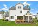 The home's back exterior has a wooden deck, a lawn, and is complimented by tasteful landscaping at 7616 Hasentree Way, Wake Forest, NC 27587
