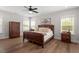 This primary bedroom offers natural light, a ceiling fan, wood flooring and an ensuite bath at 7616 Hasentree Way, Wake Forest, NC 27587