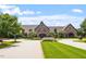 Stone clubhouse with circular driveway, landscaping, and lush lawn at 7616 Hasentree Way, Wake Forest, NC 27587