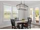 Bright dining area features a modern chandelier and view of the outdoor patio at 7616 Hasentree Way, Wake Forest, NC 27587