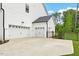 Three car garage showcasing white paint, coach lights and a concrete driveway at 7616 Hasentree Way, Wake Forest, NC 27587