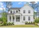 Charming two-story home with a welcoming front porch, black trimmed windows, and beautifully landscaped yard at 7616 Hasentree Way, Wake Forest, NC 27587