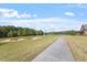 Beautiful view of a well-maintained golf course with sand traps and a paved cart path under a blue sky at 7616 Hasentree Way, Wake Forest, NC 27587