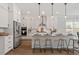 Modern kitchen with white cabinets, a center island, and stainless steel appliances providing a sleek and functional space at 7616 Hasentree Way, Wake Forest, NC 27587