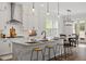 Stylish kitchen with white cabinets, stainless steel appliances, and a center island with barstools for casual dining at 7616 Hasentree Way, Wake Forest, NC 27587
