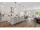 Open concept kitchen with white cabinets, stainless steel appliances, and center island with bar seating at 7616 Hasentree Way, Wake Forest, NC 27587
