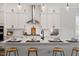 Contemporary kitchen featuring a large center island with bar stools and sleek countertops perfect for meal preparation at 7616 Hasentree Way, Wake Forest, NC 27587