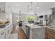 Open concept kitchen flows into the living room, featuring a center island and stainless steel appliances at 7616 Hasentree Way, Wake Forest, NC 27587