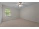 Spacious bedroom features carpet, a ceiling fan, a window overlooking the exterior, and light-colored walls at 804 Warwick Ct, Burlington, NC 27215