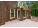 Outdoor deck area, adjacent to brick exterior and offering a view of wooded backyard at 804 Warwick Ct, Burlington, NC 27215