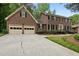 Traditional brick home featuring a two-car garage, driveway, and meticulously maintained landscaping at 804 Warwick Ct, Burlington, NC 27215