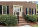 Inviting brick entryway with manicured shrubs, wrought iron railing, and a classic front door at 804 Warwick Ct, Burlington, NC 27215