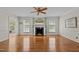 Elegant living room features a fireplace, ceiling fan, hardwood floors, and views into the sunroom at 804 Warwick Ct, Burlington, NC 27215