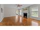 Spacious living room featuring hardwood floors, a fireplace, a ceiling fan, and views into the adjacent rooms at 804 Warwick Ct, Burlington, NC 27215