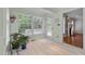 Bright sunroom featuring large windows, neutral paint, tiled floors, and views of the outdoor scenery at 804 Warwick Ct, Burlington, NC 27215