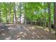 Backyard with a fire pit and seating, surrounded by trees, offers relaxation and outdoor enjoyment at 829 Joyner Ct, Wake Forest, NC 27587