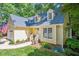 Lovely yellow home with white trim, dormer windows, mature landscaping, and an American flag at 829 Joyner Ct, Wake Forest, NC 27587