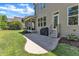Back patio with a grill, screened porch access, and views of the lush green backyard at 1012 Wandering Way, Rolesville, NC 27571