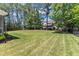 Sprawling backyard with lush green lawn, mature trees, and ample space for recreation at 1012 Wandering Way, Rolesville, NC 27571