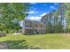 Expansive backyard featuring a well-maintained lawn, screened porch, and mature trees at 1012 Wandering Way, Rolesville, NC 27571