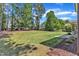 Lush green backyard with mature trees, a patio area, and well-maintained landscaping at 1012 Wandering Way, Rolesville, NC 27571