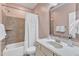 Well-lit bathroom featuring a shower-tub combination, a sink with a large mirror, and neutral-toned walls at 1012 Wandering Way, Rolesville, NC 27571