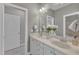 Well-lit bathroom featuring double sinks, a large mirror, and white cabinets providing ample storage space at 1012 Wandering Way, Rolesville, NC 27571