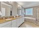 Bright bathroom features double vanity with granite countertops, soaking tub, and glass shower at 1012 Wandering Way, Rolesville, NC 27571