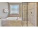 Bright bathroom features soaking tub with tile surround and glass shower at 1012 Wandering Way, Rolesville, NC 27571