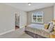 Cozy bedroom showcasing a comfortable bed, a window providing natural light, and a glimpse into an ensuite bathroom at 1012 Wandering Way, Rolesville, NC 27571