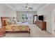 Bright bedroom with a patterned bedspread, a ceiling fan, and a window offering a pleasant view of the outdoors at 1012 Wandering Way, Rolesville, NC 27571