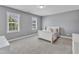Carpeted bedroom with two windows, light gray walls, and a white sleigh bed adorned with plush pillows at 1012 Wandering Way, Rolesville, NC 27571