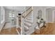 Bright foyer with hardwood floors, staircase, decorative table, and view into dining and living areas at 1012 Wandering Way, Rolesville, NC 27571