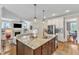 Open-concept kitchen with large island, granite countertops, stainless steel appliances, and adjacent living area at 1012 Wandering Way, Rolesville, NC 27571
