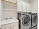 Laundry room featuring a utility sink, white cabinets, and modern LG washing machine and dryer units at 1012 Wandering Way, Rolesville, NC 27571
