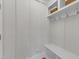 Bright mudroom with white bench, coat hooks, overhead storage, and paneled wall detail at 1012 Wandering Way, Rolesville, NC 27571