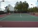 Outdoor tennis court surrounded by trees and fencing with view of residential buildings at 1012 Wandering Way, Rolesville, NC 27571