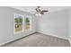 This bedroom features a ceiling fan, gray walls and large double windows at 1013 Fieldmere Pl, Wendell, NC 27591